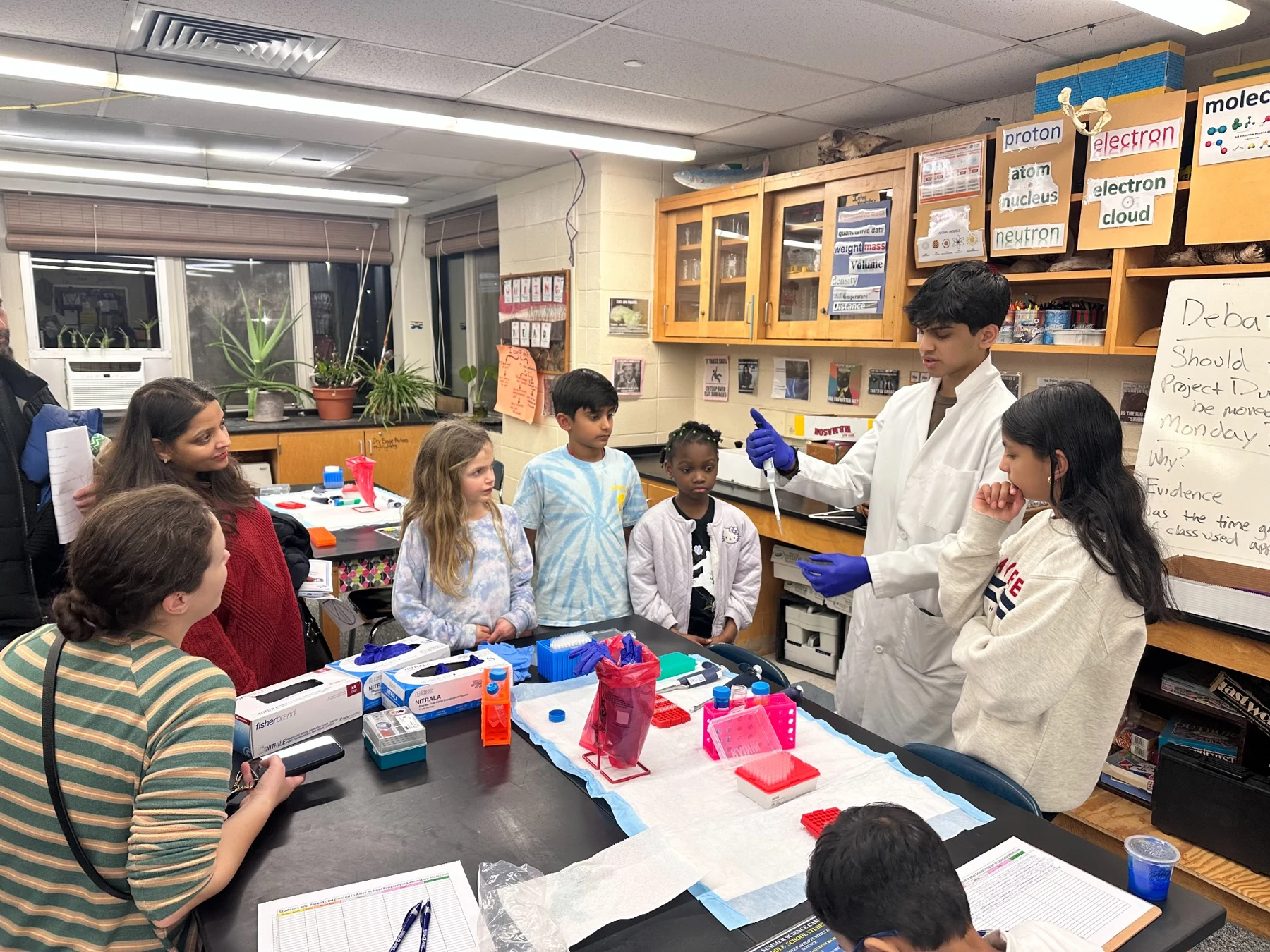 Kavin demonstrating laboratory pipetting to children and adults